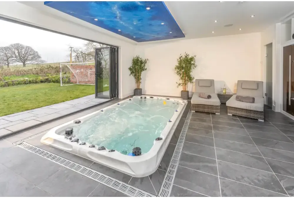 Vit PassionSpa Activity 2 Swim Spa – Sport Collection i vit med svarta jetstrålar och turkost vatten Vit PassionSpa Activity 2 Swim Spa – Sport Collection i vit med svarta jetstrålar och turkost vatten